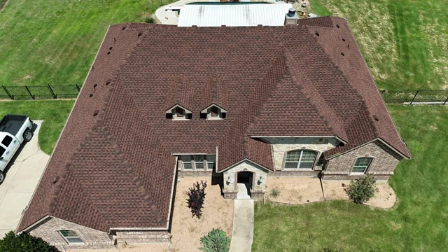 After — Hickory-colored roof on the brick and stone home