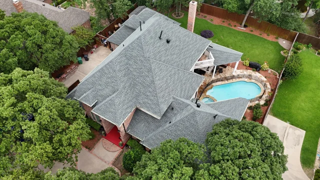 Angled view of a slate roof surrounded by trees
